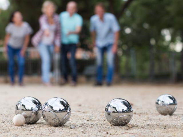 Males and females playing petanque in th park on holidays