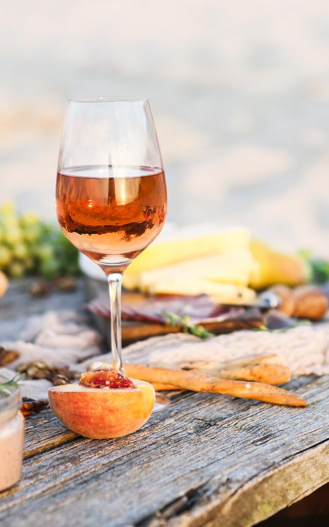 Glass of rose wine on rustic table. Food and drink background