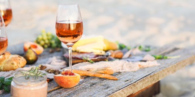 Glass of rose wine on rustic table. Food and drink background