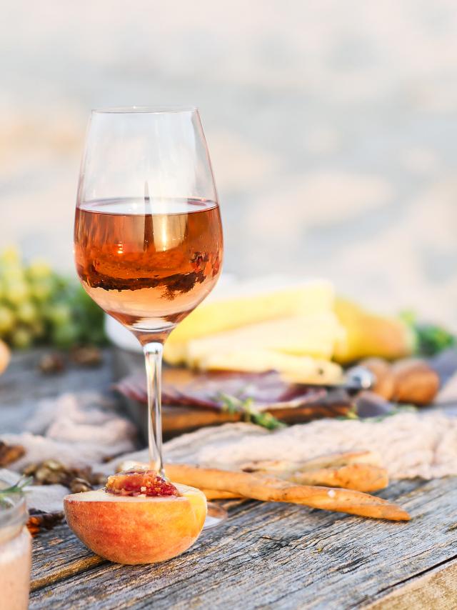 Glass of rose wine on rustic table. Food and drink background