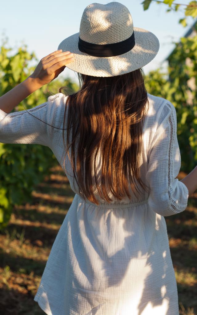 Portrait of a gorgeous brunette woman having wine fun in the vineyards.