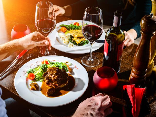 Couple having romantic dinner in a restaurant in rays of the sun